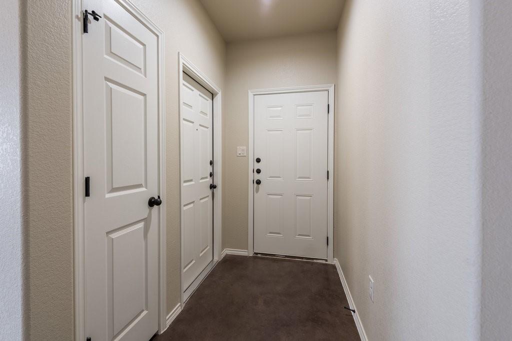 491 Jack Rabbit Lane, Unit A Buda, TX 78610 - Photo 18 of 22 A well-maintained entry hall featuring durable flooring and panel doors, offering a clean welcome.