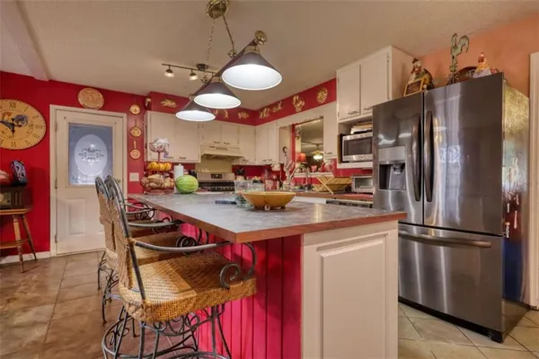 a kitchen with white cabinets and sink