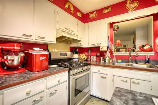 a kitchen with stainless steel appliances granite countertop a refrigerator a stove and a sink