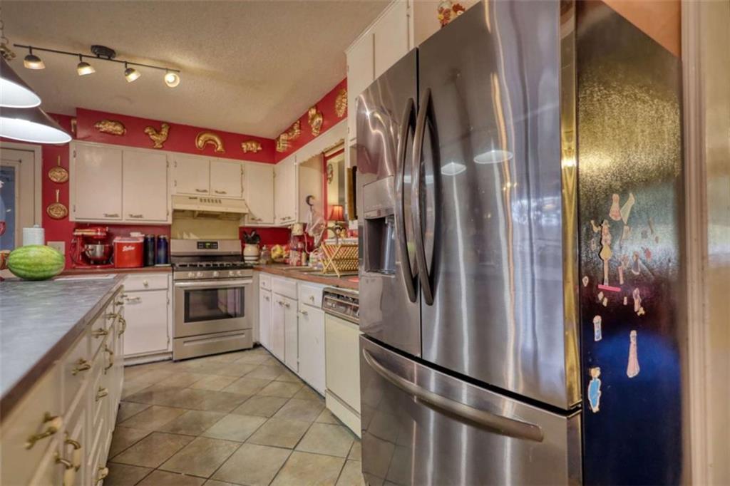 279 Spring Street Winder, GA 30680 - Photo 16 of 43 a kitchen with stainless steel appliances granite countertop a refrigerator a stove and a sink