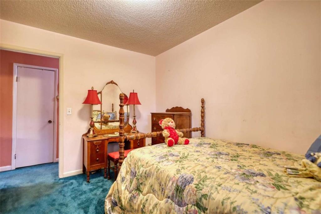 279 Spring Street Winder, GA 30680 - Photo 18 of 43 a bed room with a bed and a desk