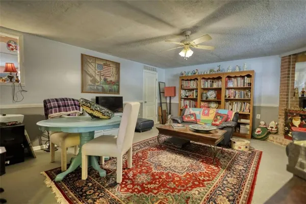 a living room with furniture a bookshelf and a window