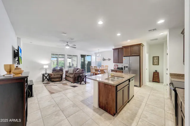 a kitchen with stainless steel appliances granite countertop a stove top oven a sink and a refrigerator