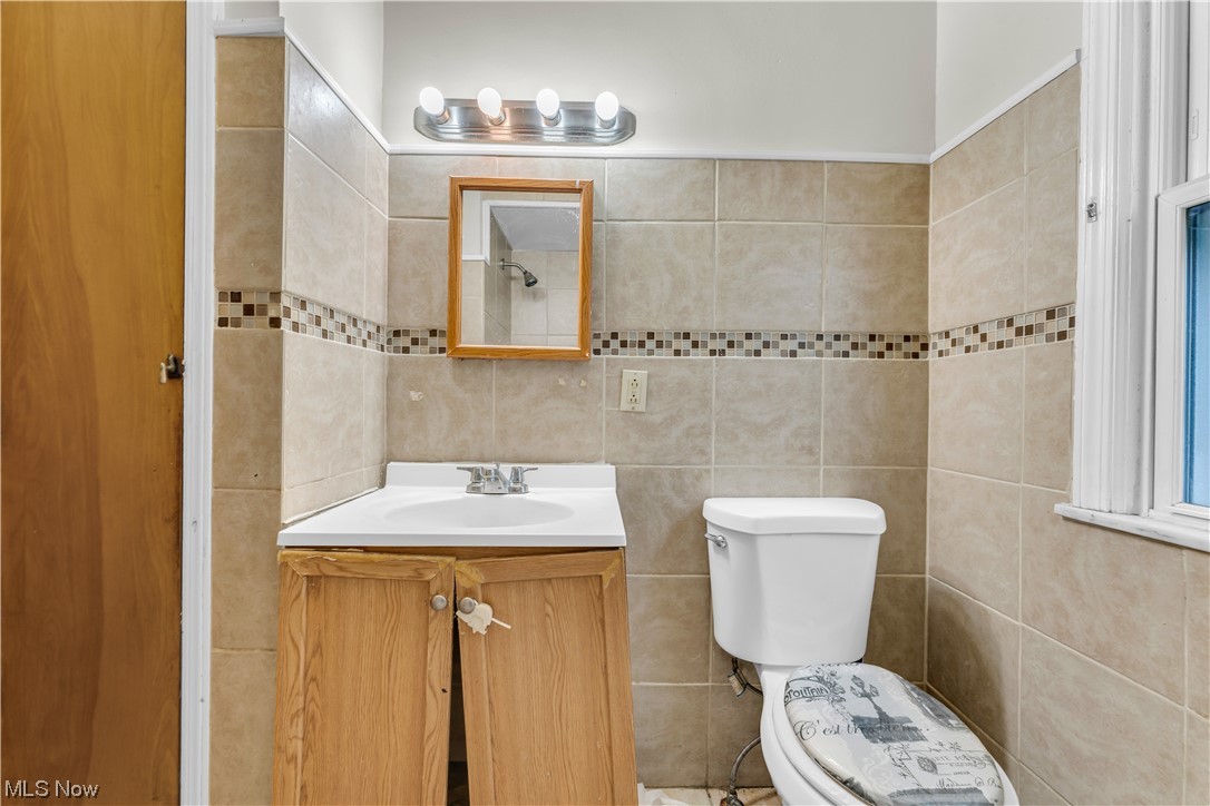 5619 Dunham Road Maple Heights, OH 44137 - Photo 12 of 19 Bathroom featuring tile walls, vanity, and toilet
