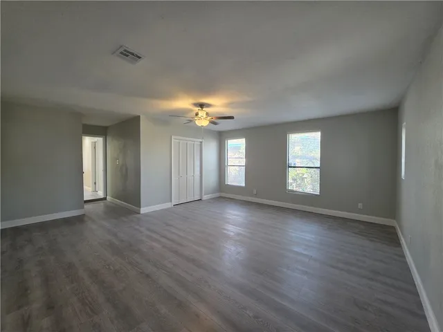 a view of an empty room with wooden floor