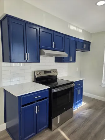 a kitchen with stainless steel appliances granite countertop wooden cabinets and a stove top oven