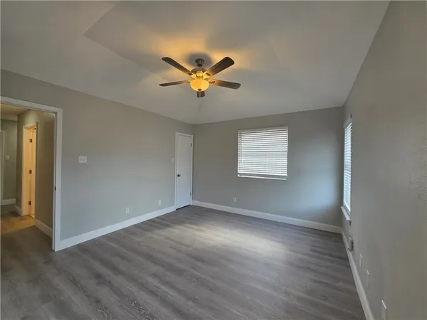 a view of an empty room with wooden floor