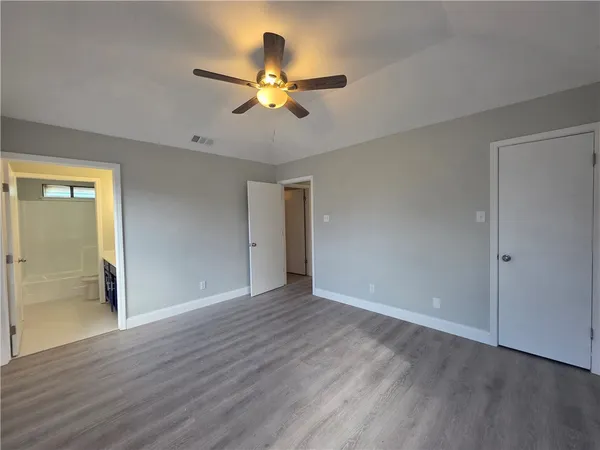 a view of wooden floor and a chandelier fan in a room