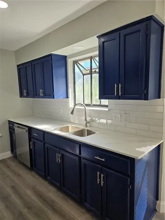 a kitchen with granite countertop wooden cabinets