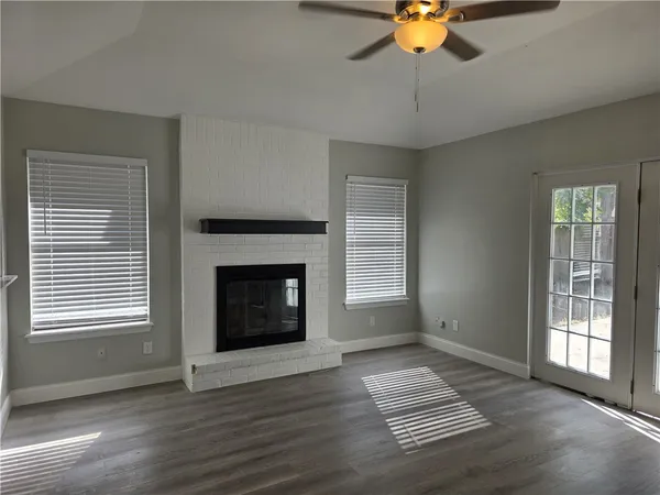 a view of an empty room with window and fireplace