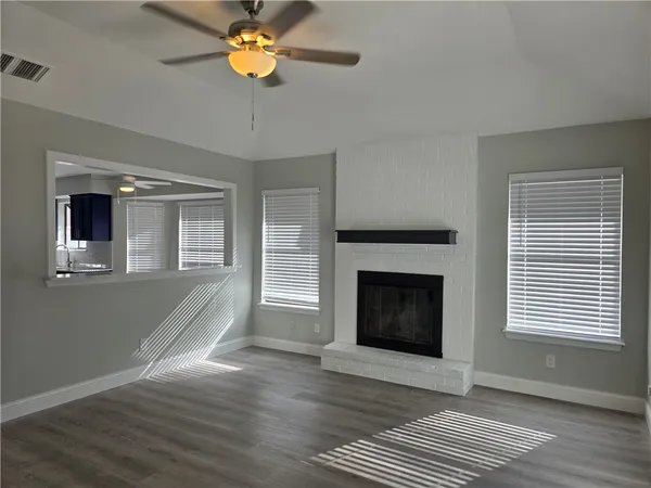 a view of a livingroom with a fireplace and wooden floor