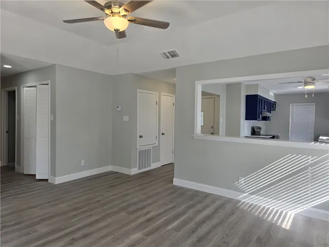a view of a livingroom with a chandelier fan and wooden floor