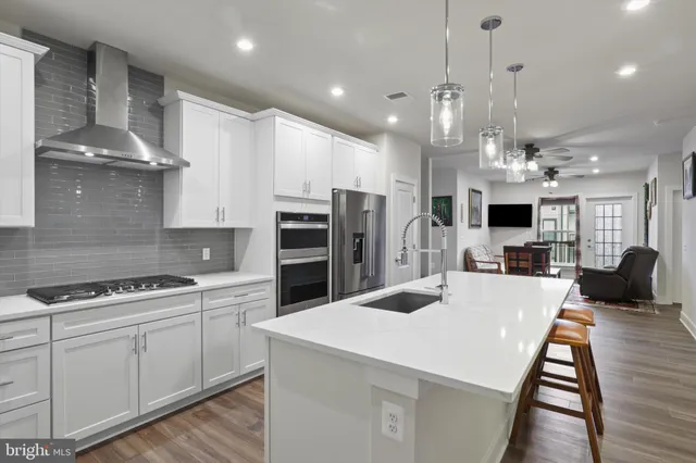 a kitchen with stainless steel appliances kitchen island granite countertop a stove a sink a refrigerator and a cabinets