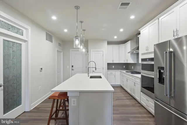 a kitchen with stainless steel appliances a refrigerator sink and stove