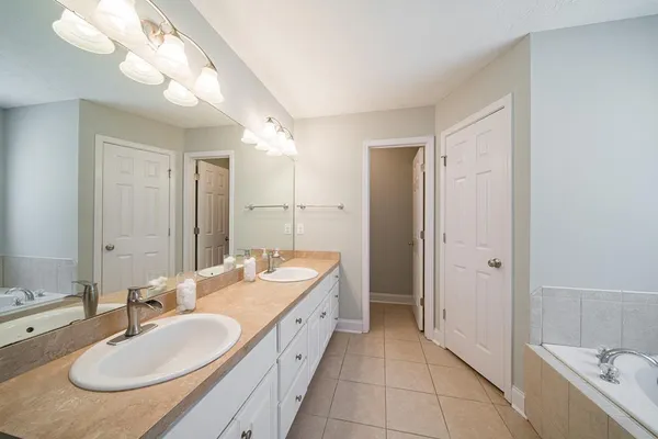 a bathroom with a double vanity sink and a mirror