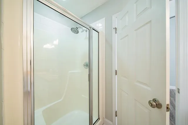 a bathroom with a glass shower door and a glass door