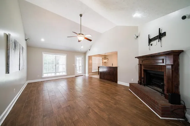 a view of empty room with wooden floor and fireplace