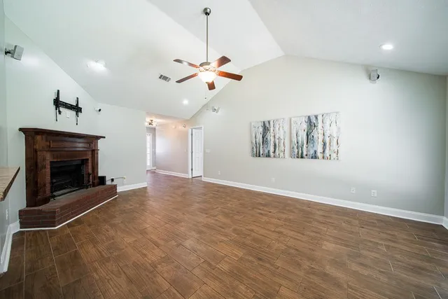 an empty room with windows and fireplace