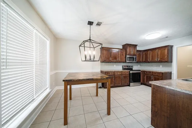 a kitchen with stainless steel appliances granite countertop a sink a stove top oven a counter space and cabinets