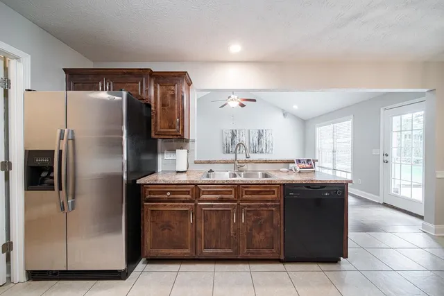 a kitchen with a sink a refrigerator and wooden cabinets