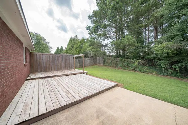 a view of backyard with swimming pool and small garden