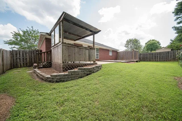 a view of a backyard with table and chairs with wooden fence