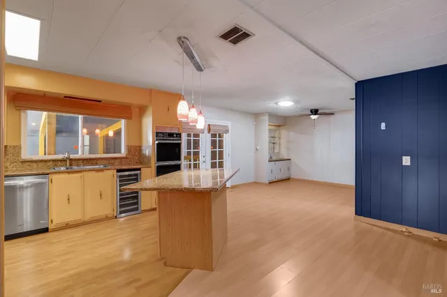 a kitchen with granite countertop a sink stainless steel appliances and cabinets