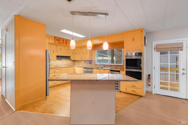 a kitchen with granite countertop white cabinets and stainless steel appliances