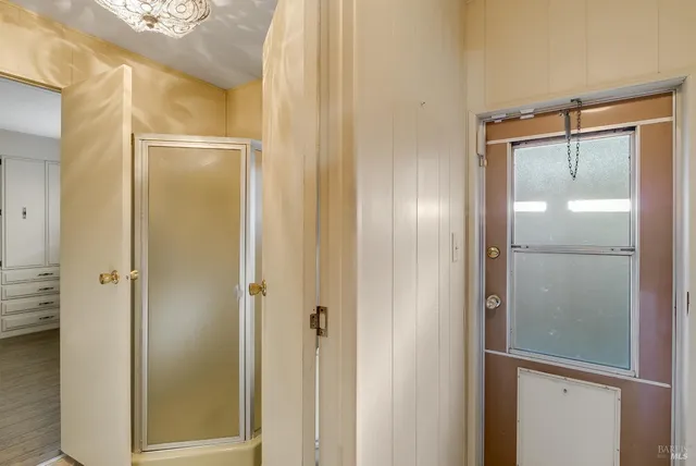 a view of a hallway with bathroom and wooden floor