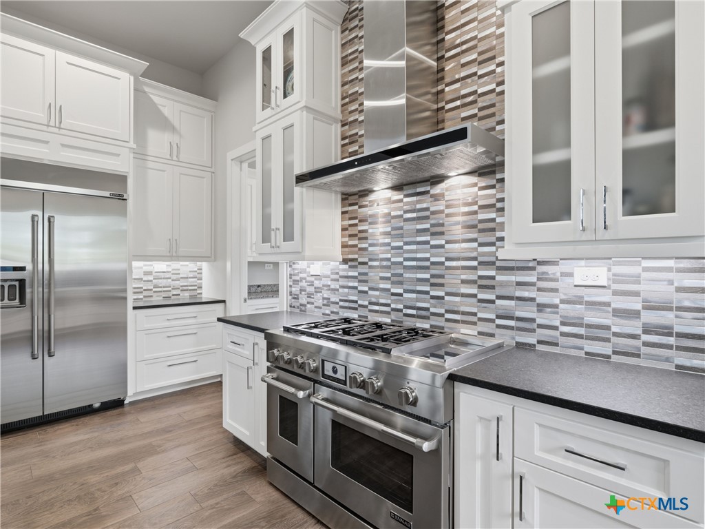 5913 Verden Ridge New Braunfels, TX 78132 - Photo 8 of 48 a kitchen with cabinets stainless steel appliances and wooden floor