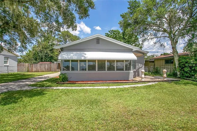 a view of a house with a yard and sitting area