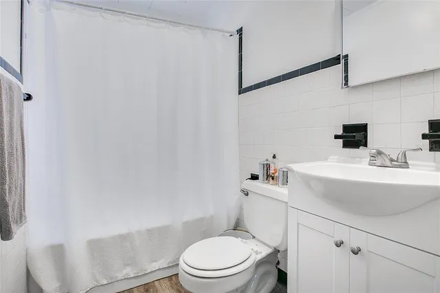 a bathroom with a sink a toilet and shower curtain
