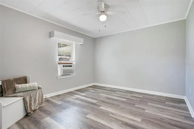 an empty room with a window and wooden floor