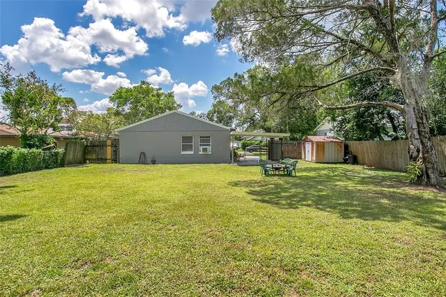 a front view of house with yard and trees in the background