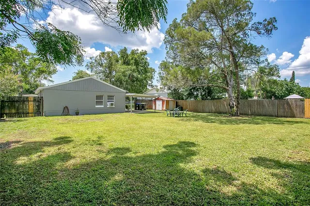 a front view of house with yard and trees in the background