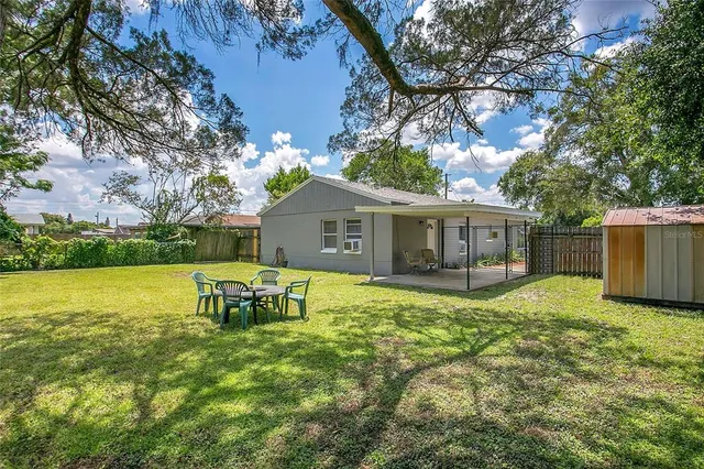 a backyard of a house with table and chairs