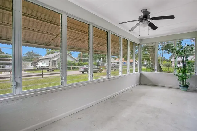 a living room with a large window and a chandelier