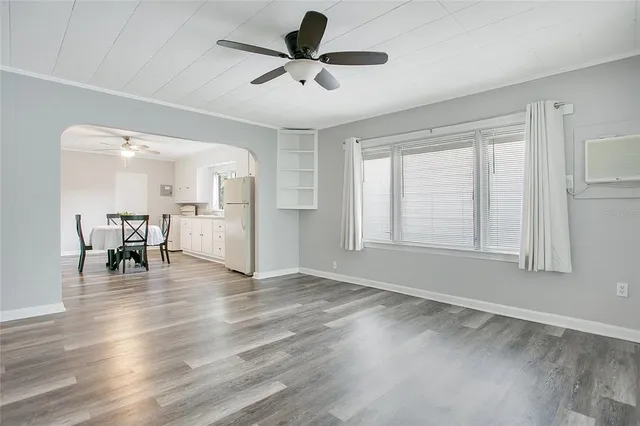 a view of a livingroom with furniture a ceiling fan and window