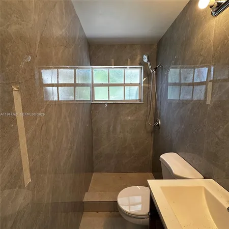 a bathroom with a toilet a sink and window