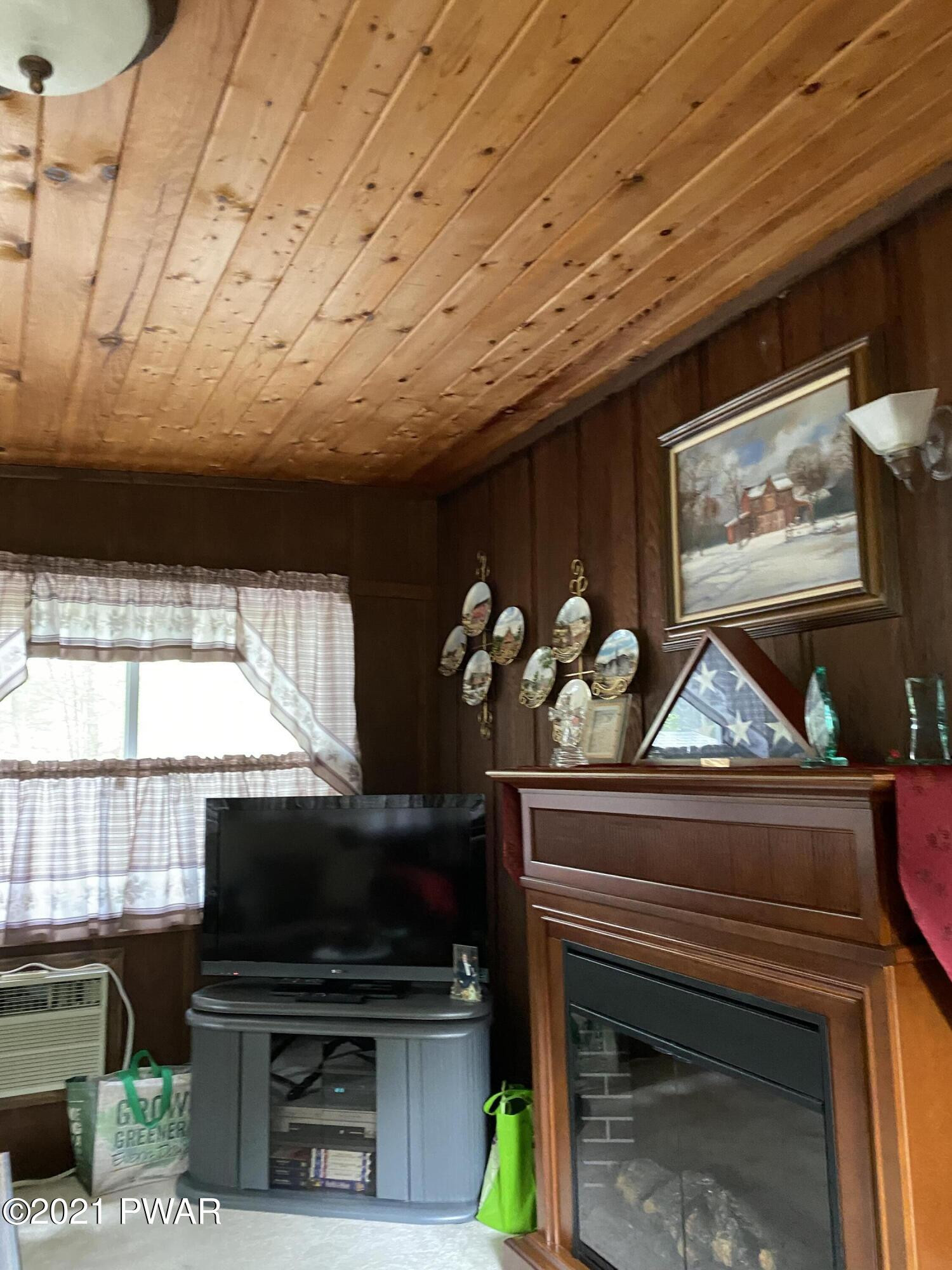 125 Maple Ridge Drive Hawley, PA 18428 - Photo 19 of 49 a living room with furniture a flat screen tv and a fireplace