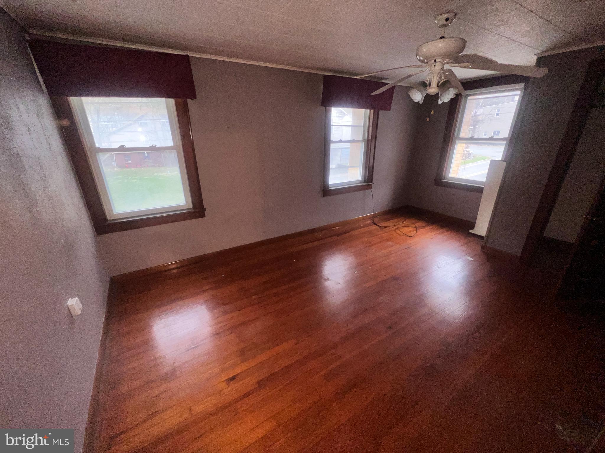15515 Mt Savage Road Northwest Mount Savage, MD 21545 - Photo 18 of 39 an empty room with wooden floor and windows