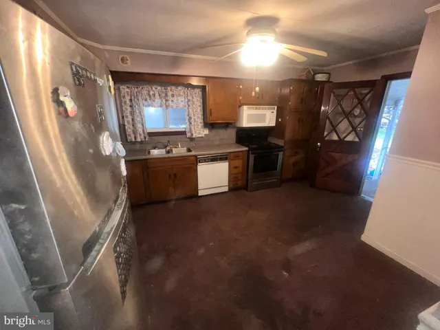 a large kitchen with lot of cabinets and glass door