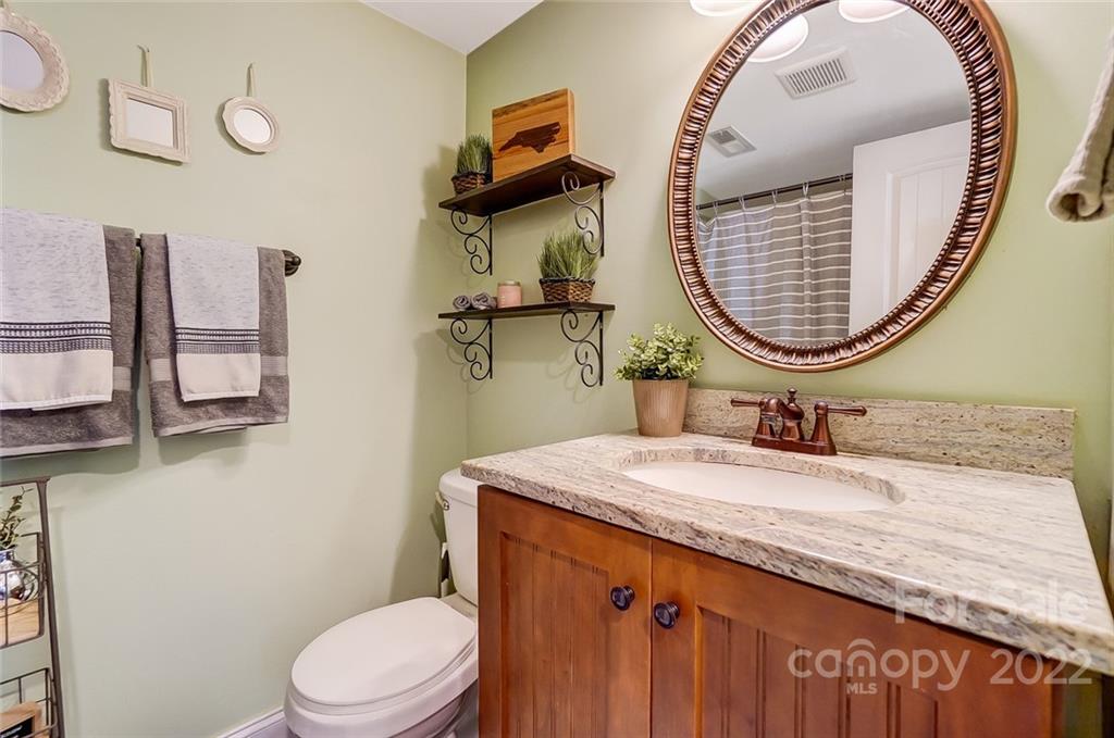 4919 Park Road, Unit C Charlotte, NC 28209 - Photo 32 of 41 a bathroom with a granite countertop toilet sink mirror and vanity