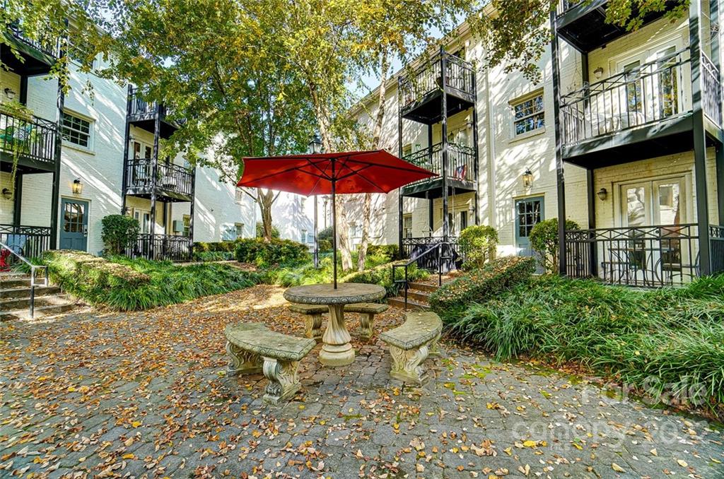 4919 Park Road, Unit C Charlotte, NC 28209 - Photo 40 of 41 a view of a patio with a table and chairs under an umbrella