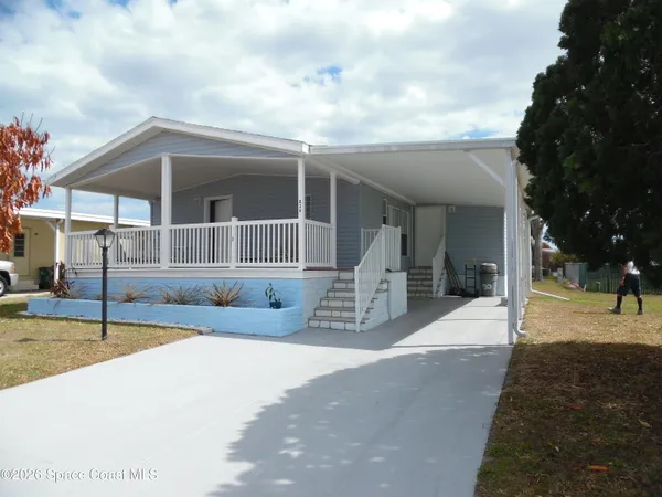 a view of a house with backyard and sitting area