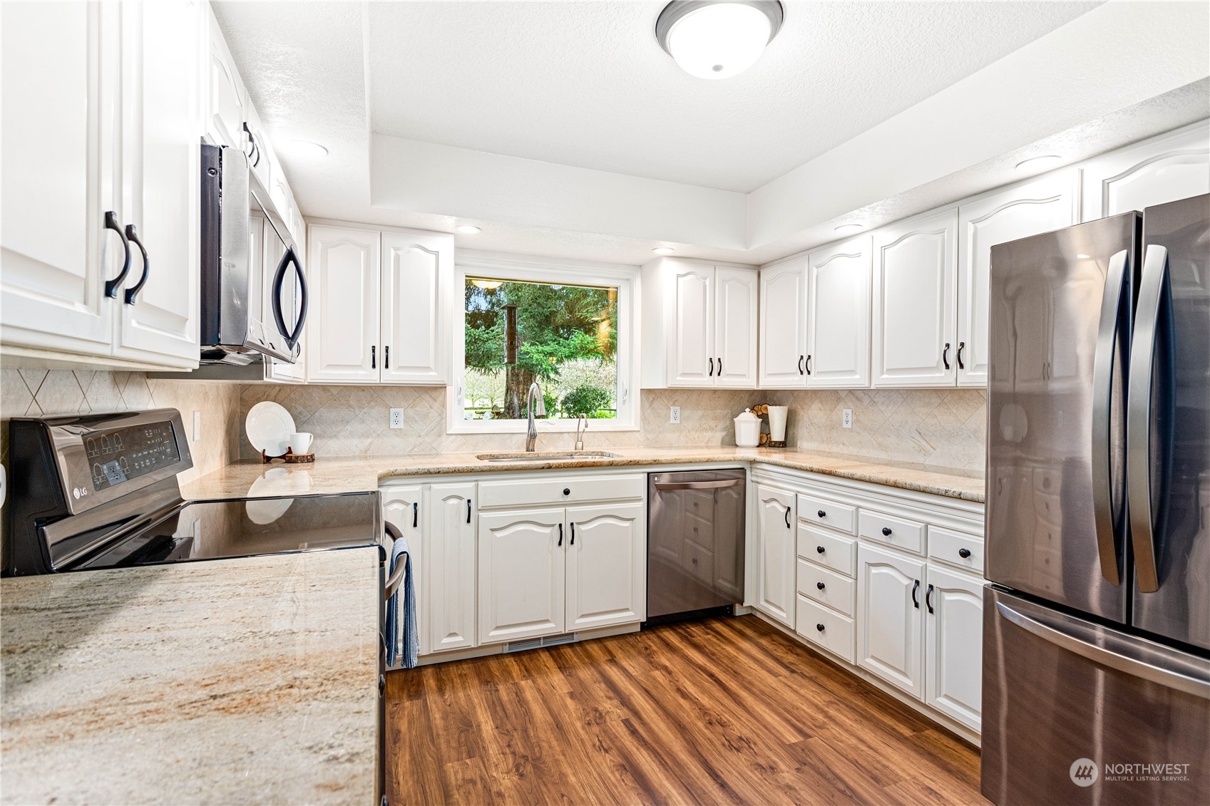 8669 Berthusen Road Lynden, WA 98264 - Photo 11 of 39 a kitchen with granite countertop a sink stainless steel appliances and cabinets