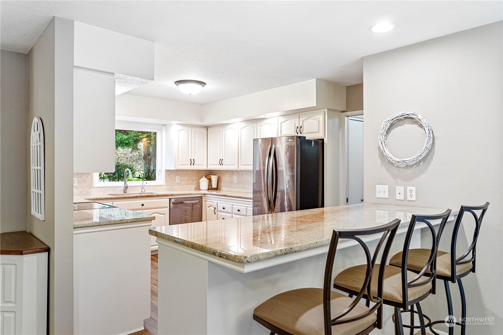 8669 Berthusen Road Lynden, WA 98264 - Photo 9 of 39 a kitchen with stainless steel appliances granite countertop a dining table chairs refrigerator and sink