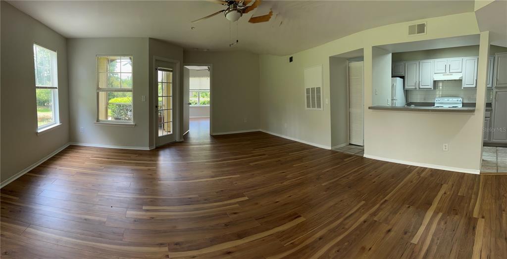 413 Summit Ridge Place, Unit 115 Longwood, FL 32779 - Photo 11 of 44 an empty room with wooden floor and windows