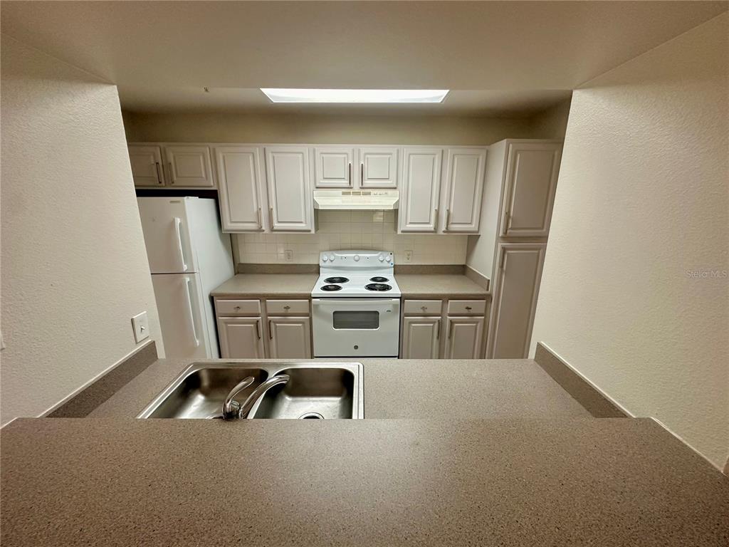 413 Summit Ridge Place, Unit 115 Longwood, FL 32779 - Photo 12 of 44 a kitchen with a stove a sink and a refrigerator