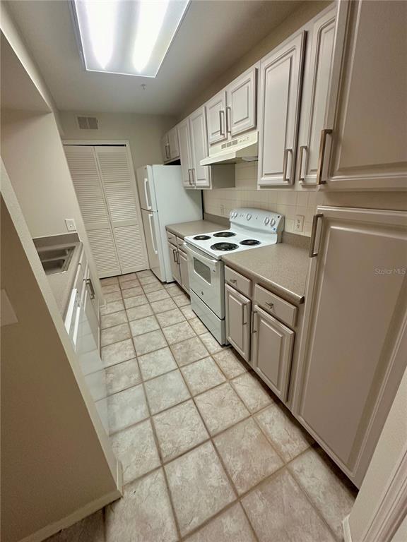 413 Summit Ridge Place, Unit 115 Longwood, FL 32779 - Photo 13 of 44 a kitchen with stainless steel appliances granite countertop a stove a sink and a refrigerator